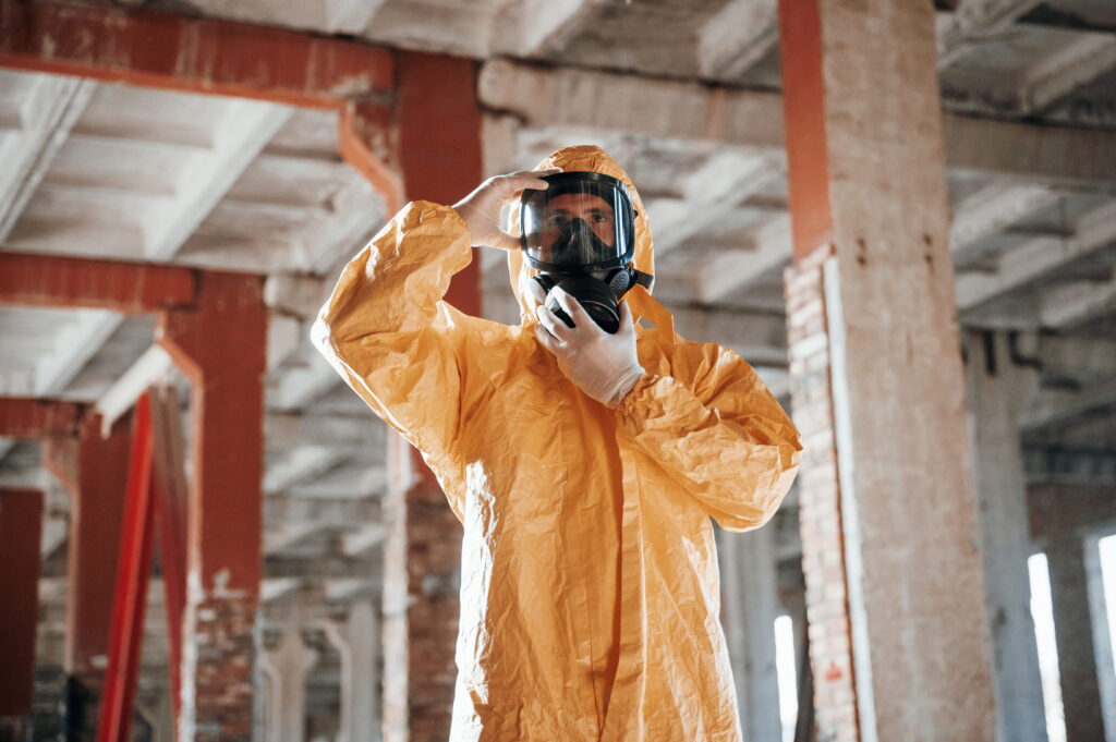 man dressed in asbestos protection suit in a roof
